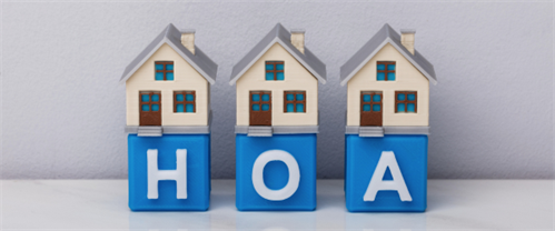 3 toy homes sitting on top of 3 blocks that spell out HOA